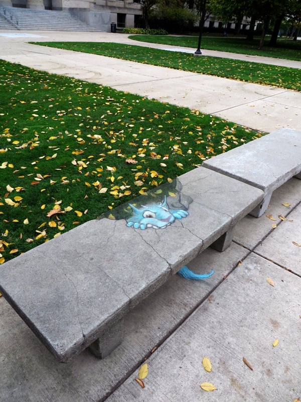 Blue monster eating a concrete bench illusion by David Zinn