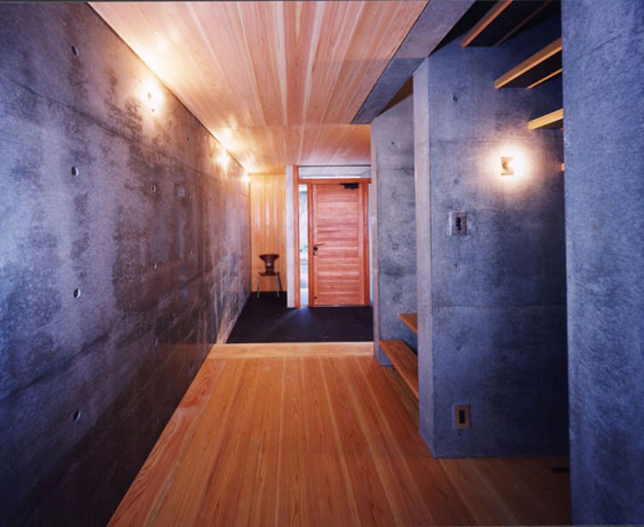 Warm Wood Floors and Ceilings Contrasting with Cold Concrete Walls