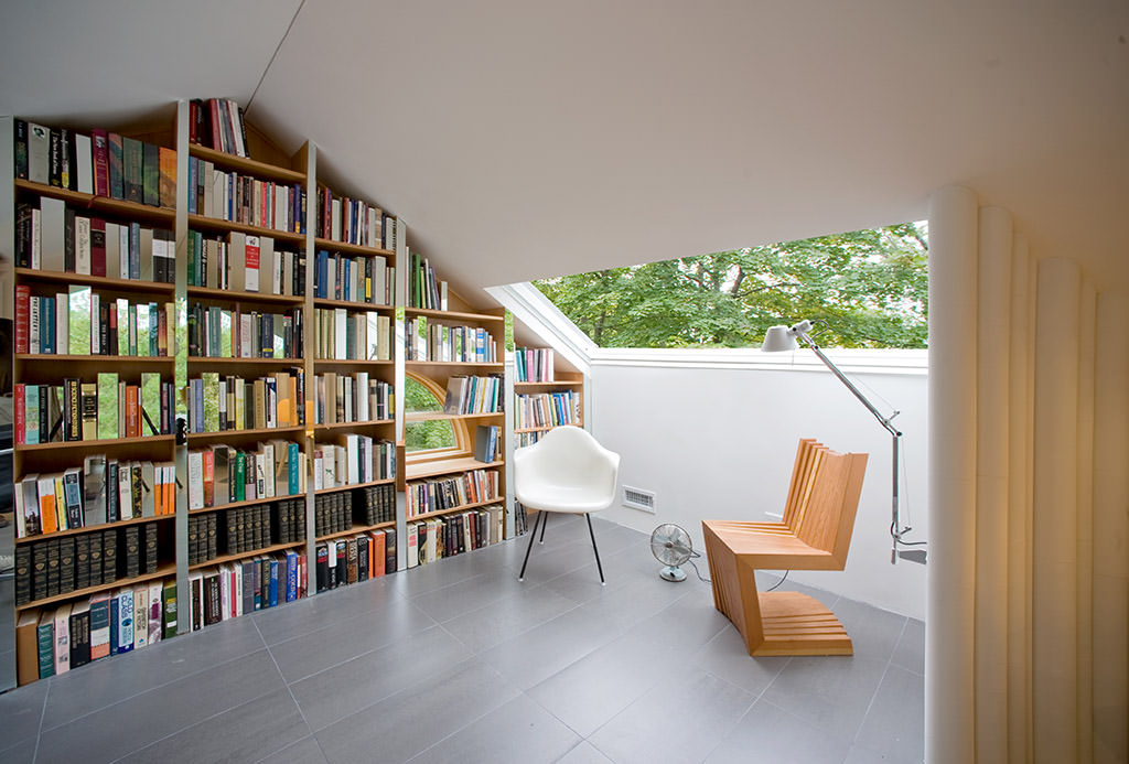 Full-wall bookshelf and reading area of Crawford Attic Writing Room by PARA-project