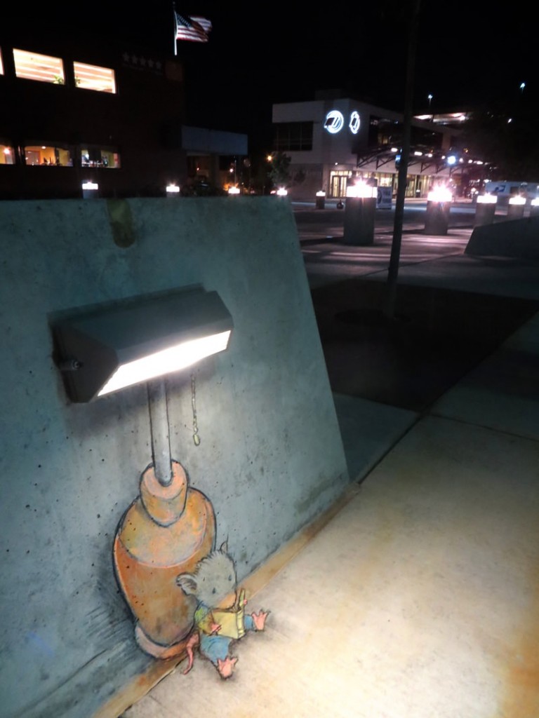 Mouse reading a book under a street light in trompe l'oeil chalk street at by David Zinn
