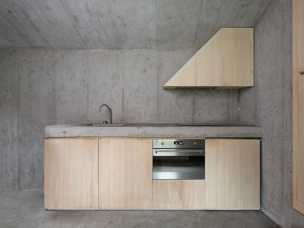Minimalist Concrete and Plywood Kitchen in Refugi Lieptgas